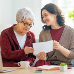 a young woman helps her grandmother with a document