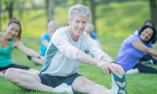 a senior man doing yoga in the park