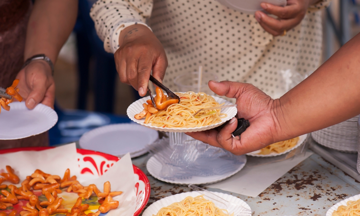 people gathering food from plates